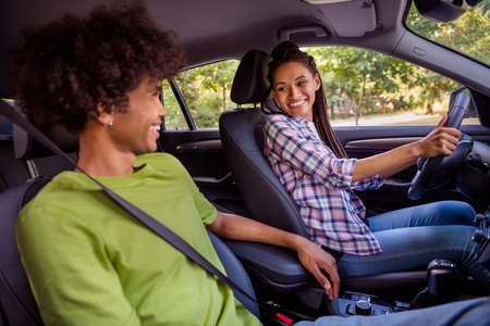 Profile side view portrait of attractive cheerful couple spending weekend holiday driving car...