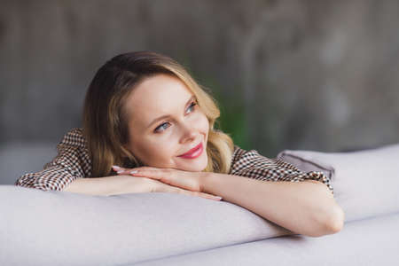 Photo portrait young woman smiling relaxing on sofa at home
