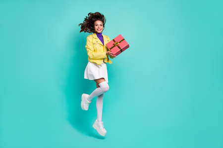 Full size profile side photo of young cheerful girl have fun jumper get present isolated over teal color backgroundの写真素材