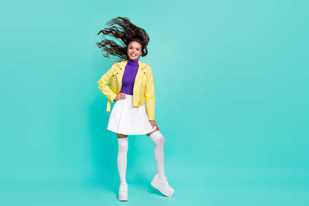 Full body photo of young charming woman fly hair fall outfit platform isolated over teal color backgroundの写真素材