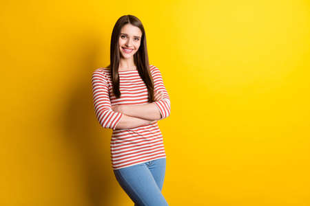 Portrait of attractive cheerful girl folded arms copy empty space isolated over bright yellow color backgroundの写真素材