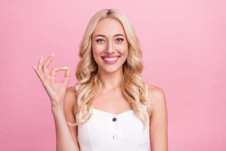 Photo of young girl happy positive smile show fingers okay alright sign perfect feedback isolated over pastel color backgroundの写真素材
