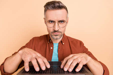 Portrait of focused mature professional guy text netbook look webcamera client consult briefing isolated over pastel color backgroundの写真素材