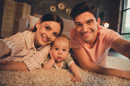 Photo of dad daddy mom mommy make selfie with cute infant daughter on carpet floor night dark room...