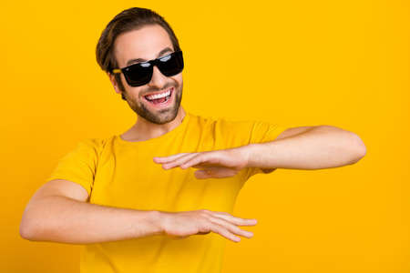 Photo of young guy good mood eyewear vacation festive event trip isolated over yellow color backgroundの写真素材