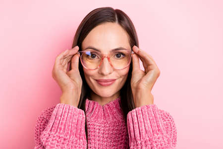Photo of cute young brunette lady wear eyewear pink pullover isolated on pastel color backgroundの写真素材