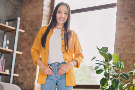 Photo of pretty shiny mature woman wear yellow shirt smiling enjoying staying home indoors house...