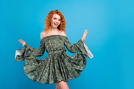 Photo of young cheerful pretty girl happy positive smile wear dress isolated over blue color backgroundの写真素材