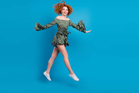 Full length profile photo of sweet ginger hairdo lady jump wear dress sneakers isolated on blue...