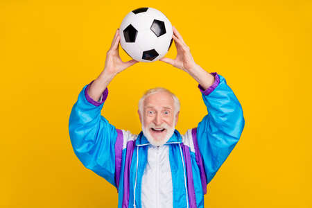 Photo of senior man pensioner practice wear old fashioned costume intense activity isolated over yellow color backgroundの写真素材