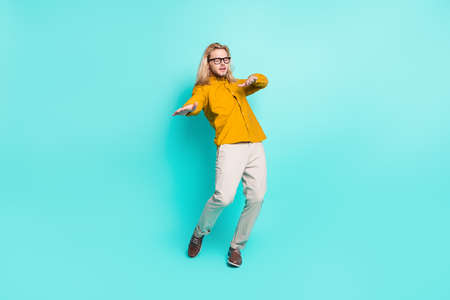 Full body photo of young handsome man have fun enjoy music dance disco hip-hop isolated over turquoise color backgroundの写真素材