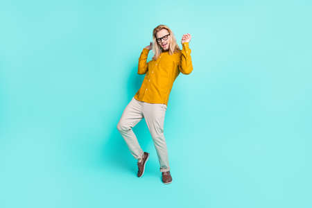 Full size photo of young handsome man have fun dance party enjoy excited isolated over turquoise color backgroundの写真素材