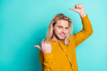 Profile side photo of young man happy positive smile show thumbs empty space recommend advertise isolated over teal color backgroundの写真素材