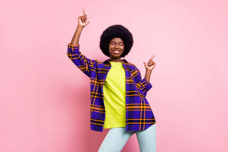 Portrait of attractive cheerful girl dancing having fun chill relax free time isolated over pink pastel color backgroundの写真素材