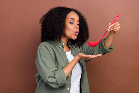 Profile photo of housewife brunette young lady cooker wear grey shirt isolated on brown color backgroundの写真素材