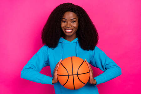 Photo portrait of woman smiling keeping ball spending free time isolated vivid pink color backgroundの写真素材