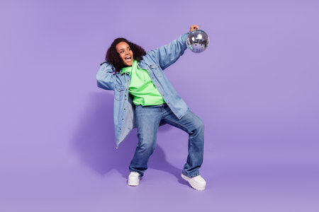 Full size portrait of excited carefree person hold discoball look copyspace good mood isolated on violet color backgroundの写真素材