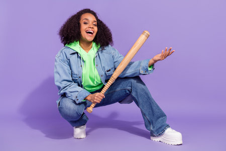 Full length portrait of brutal hooligan girl hold bat toothy smile look camera isolated on violet...