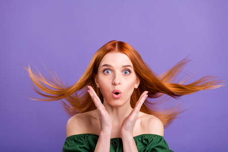 Photo of cute shocked young lady wear green blouse arms cheeks cheekbones isolated purple color backgroundの写真素材
