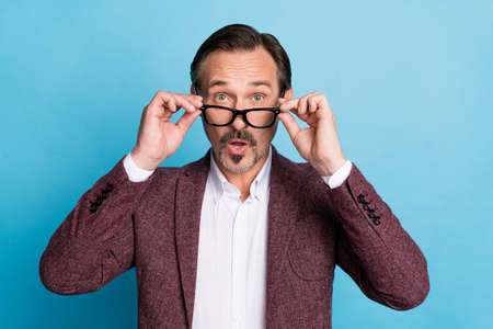 Photo of excited executive boss man omg sale reaction wear eyewear red blazer isolated blue color backgroundの写真素材