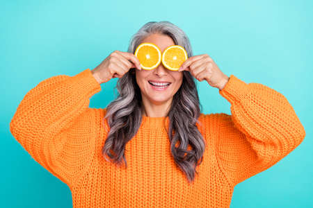 Photo of senior lovely woman have fun cover eyes citrus good mood hiding playful isolated over teal...