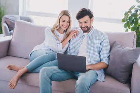 Photo of sociable friends spend free time together watch movie wear casual outfit in comfortable home indoorsの写真素材