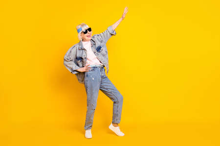 Full length body size view of attractive glad cheerful woman having fun weekend isolated over bright yellow color backgroundの写真素材