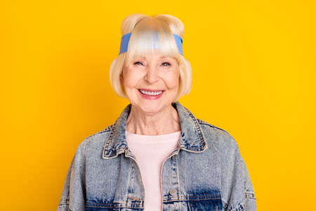 Photo portrait of cool positive granny smiling wearing stylish clothes isolated on bright yellow color backgroundの写真素材