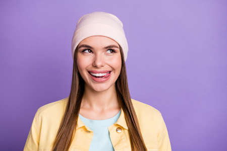 Portrait of optimistic straight hairdo girl tongue out look empty space wear cap jacket isolated on purple color backgroundの写真素材