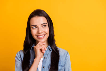 Portrait of adorable person hand on chin look interested empty space toothy smile isolated on yellow...