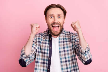 Photo of young man happy positive smile rejoice victory champion goal fists hands isolated over pink color backgroundの写真素材