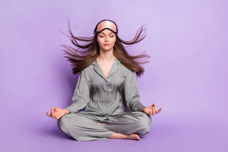 Full length body size photo of calm woman sitting in lotus pose practicing yoga isolated on pastel...