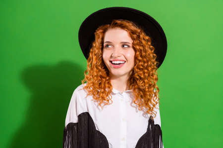 Portrait of attractive cheerful wavy-haired girl looking aside copy blank space isolated over bright green color backgroundの写真素材