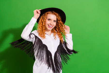 Portrait of attractive cheerful wavy-haired girl dancing having fun touching hat isolated over...