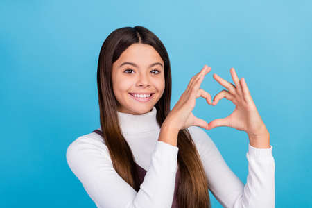 Photo of youth lovely lady show fingers heart shape romantic feelings cupid isolated over blue color...