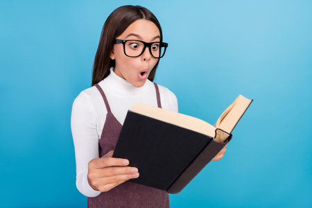 Profile side photo of youth lady impressed astonished read book lesson novel isolated over blue...