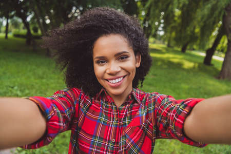 Photo portrait woman walking in city park taking selfie smiling keeping camera having good mood
