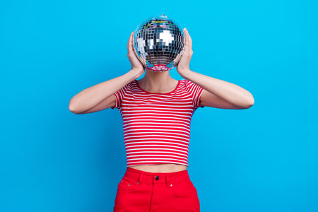 Photo portrait girl covered face with disco ball at party isolated vivid blue color backgroundの写真素材