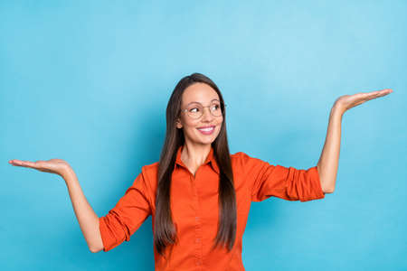 Photo of sweet shiny mature lady dressed red shirt glasses showing arms scales looking empty space...