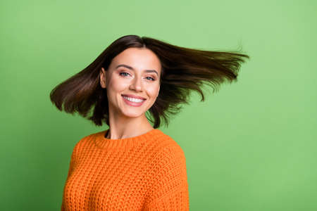 Portrait of attractive cheerful brunette girl throwing hair having fun isolated over bright green...