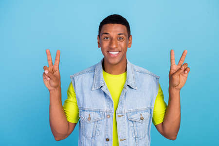 Photo of young cheerful afro man good mood show peace cool v-symbol isolated over blue color...