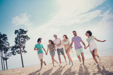 Photo of cute adorable young six friends wear casual clothes walking holding arms smiling outside countrysideの写真素材