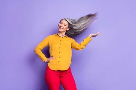 Portrait of attractive dreamy cheerful woman posing throwing hair isolated over bright violet purple color backgroundの写真素材
