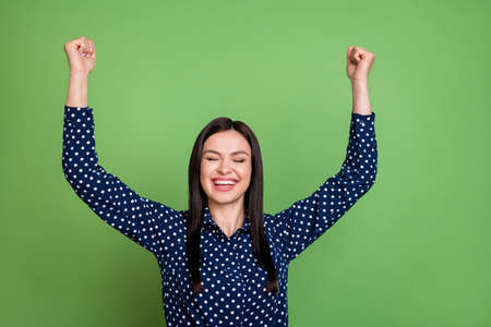 Photo of astonished brunette hairdo ceo lady hands up wear blue shirt isolated on green color backgroundの写真素材