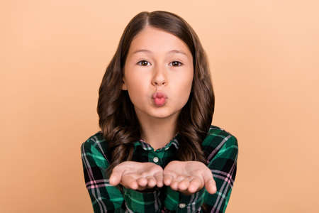 Photo of pretty charming little girl pout lips send young air kiss wear checkered shirt isolated on...