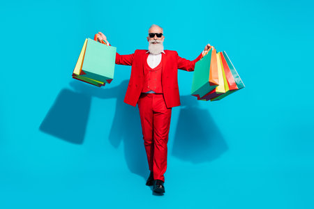 Full length body size photo aged man cheerful walking on shopping in center isolated vivid blue color backgroundの写真素材