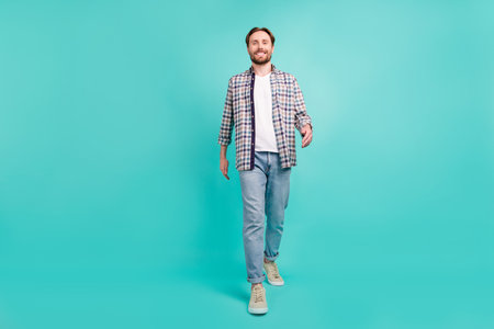 Full length body size photo man smiling walking forward isolated pastel turquoise color background