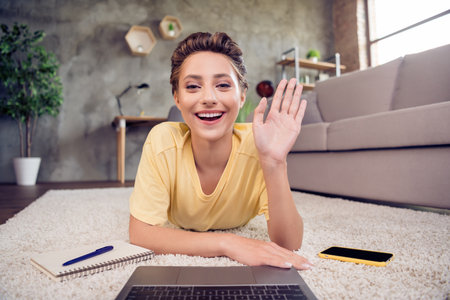 Photo of friendly freelancer lady use netbook remote conference wave hand camera wear yellow t-shirt...