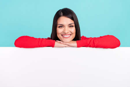 Photo of dreamy charming young lady dressed red pullover smiling arm having rest big white card...