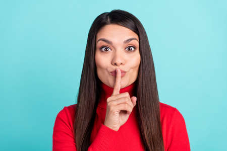Photo of charming confident young lady dressed red pullover smiling finger lips asking keep secret...